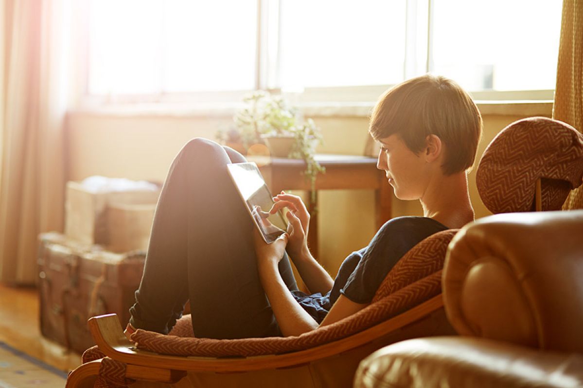 Woman sitting on sofa looking at ipad