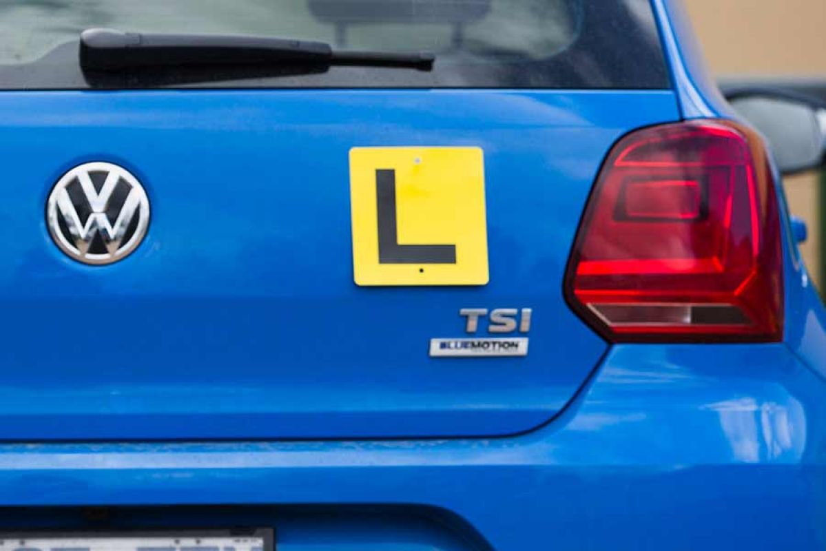 Back of blue car with yellow L plate.
