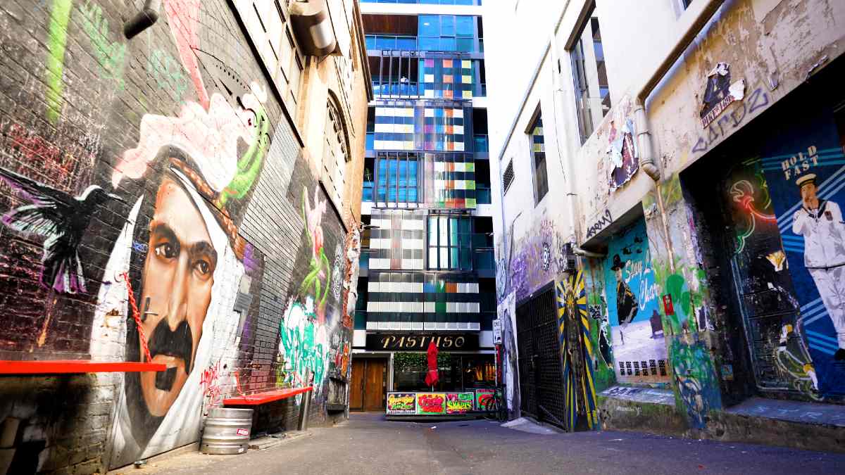 Multiple murals line the walls of ACDC Lane, while restaurant Pastuso can be seen in the background.