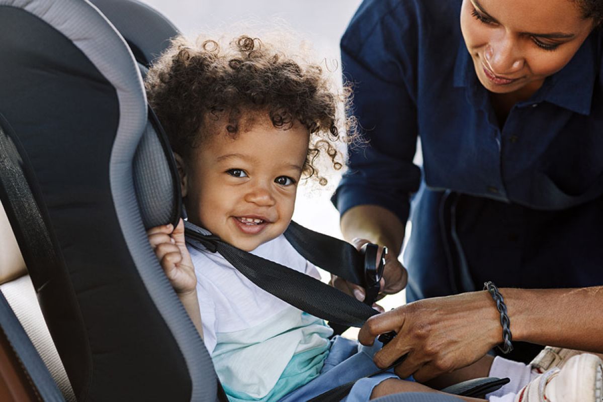 Child sitting in forward-facing child car seat.