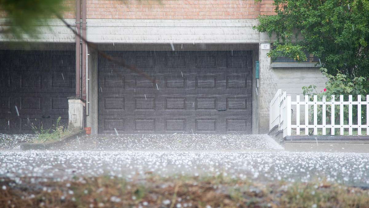 Hail falling in front of a black garage door