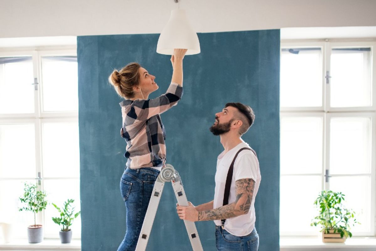 man and woman changing lightbulb