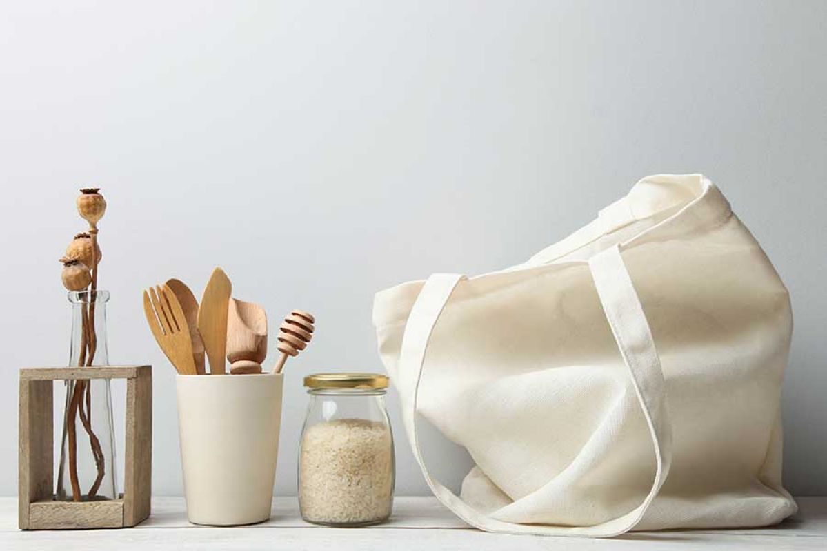 Cotton tote and disposable wooden cutlery on white background