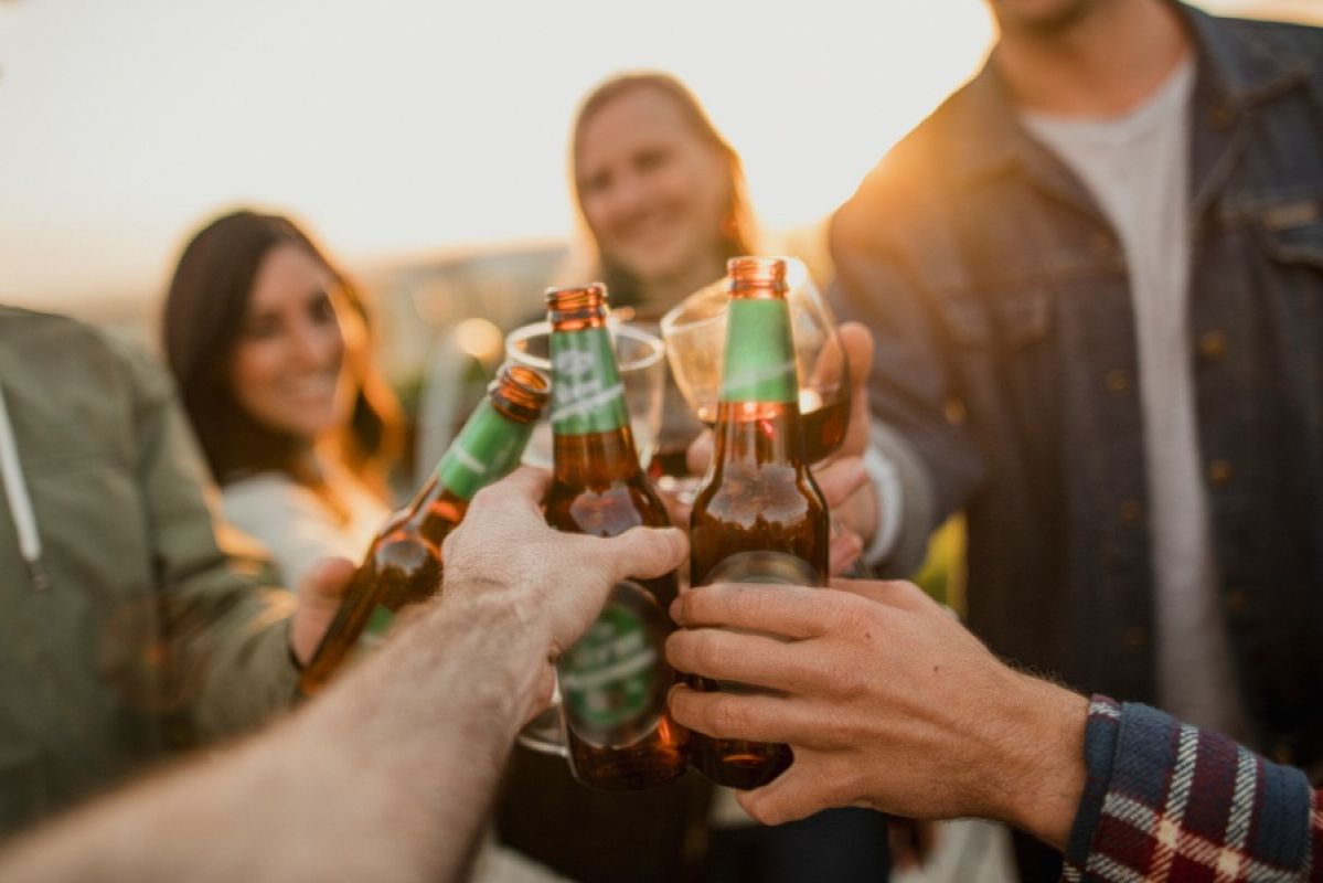 People clinking beer bottles together