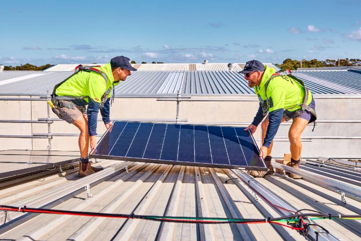 two RACV Solar technicians installing solar panels on a roof