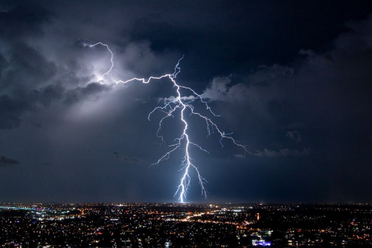 lightning strike from storm over city lights