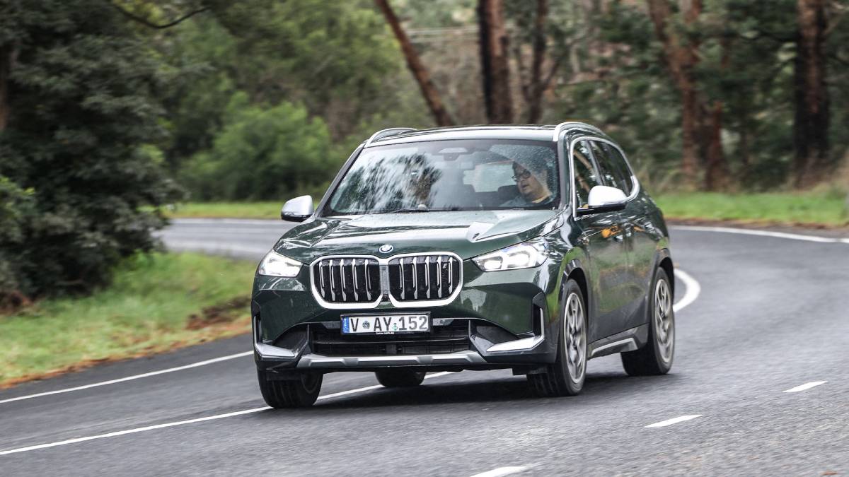 BMW iX1 driving on wet road