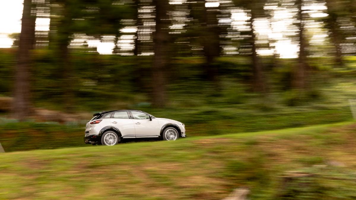 2024 Mazda CX-3 Touring SP driving up a hill