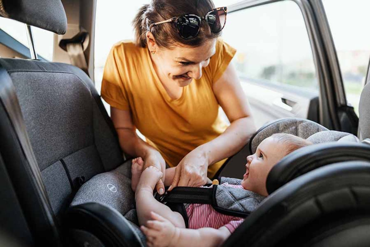 Woman securing baby in car seat