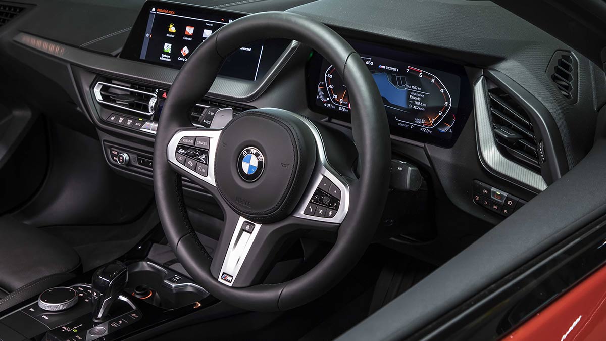 Interior of the BMW M235i xDrive Gran Coupe car showing the steering wheel and centre console