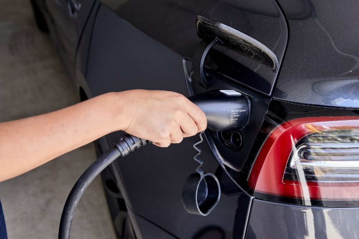 woman charging her Tesla electric vehicle at home