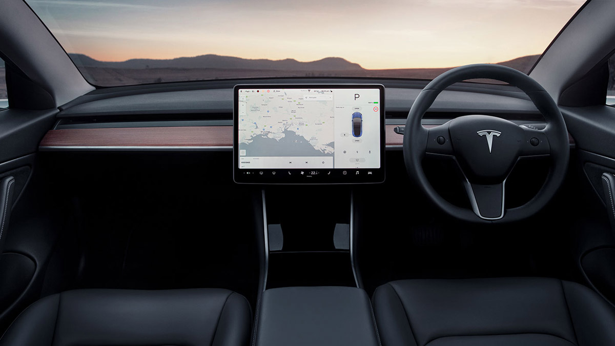 Interior view of the Tesla Model 3 featuring the dashboard, central screen and steering column