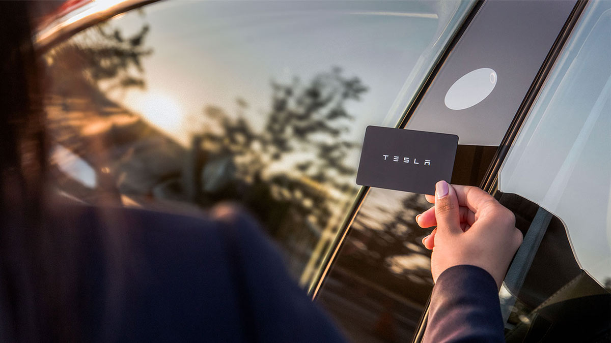 Woman swiping a card against a sensor on the Tesla Model 3's B-Pillar.