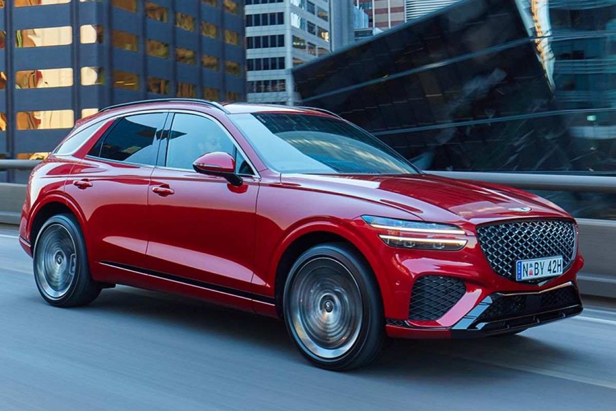 A red Genesis GV70 on the road.