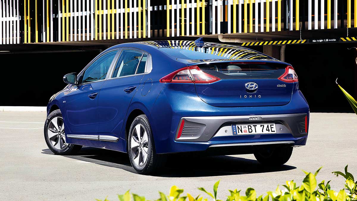 Rear side view of a blue Hyundai Ioniq 2019 car parked in front of a multi level carpark