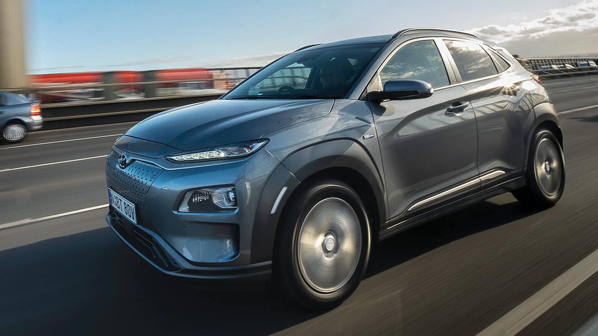 Front side view of a dark grey Hyundai Kona in motion on a freeway