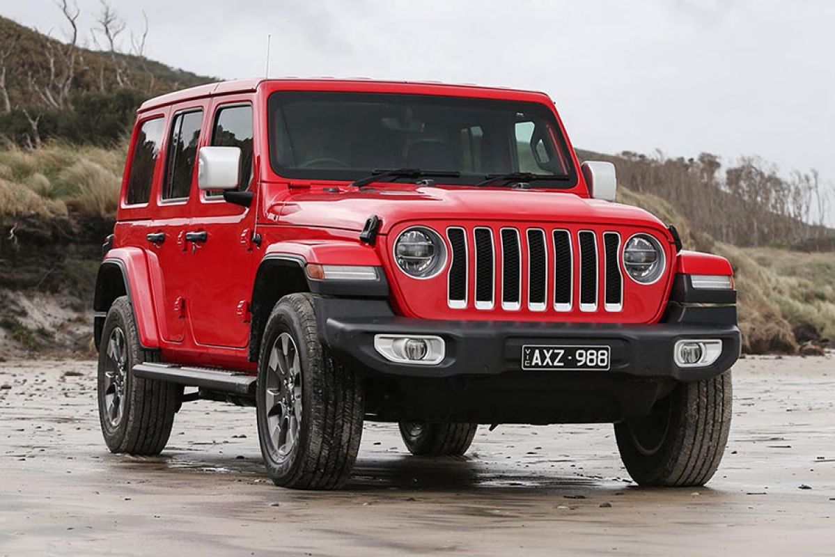 Front view of a red Jeep Wrangler JL 2019 car parked on a beach