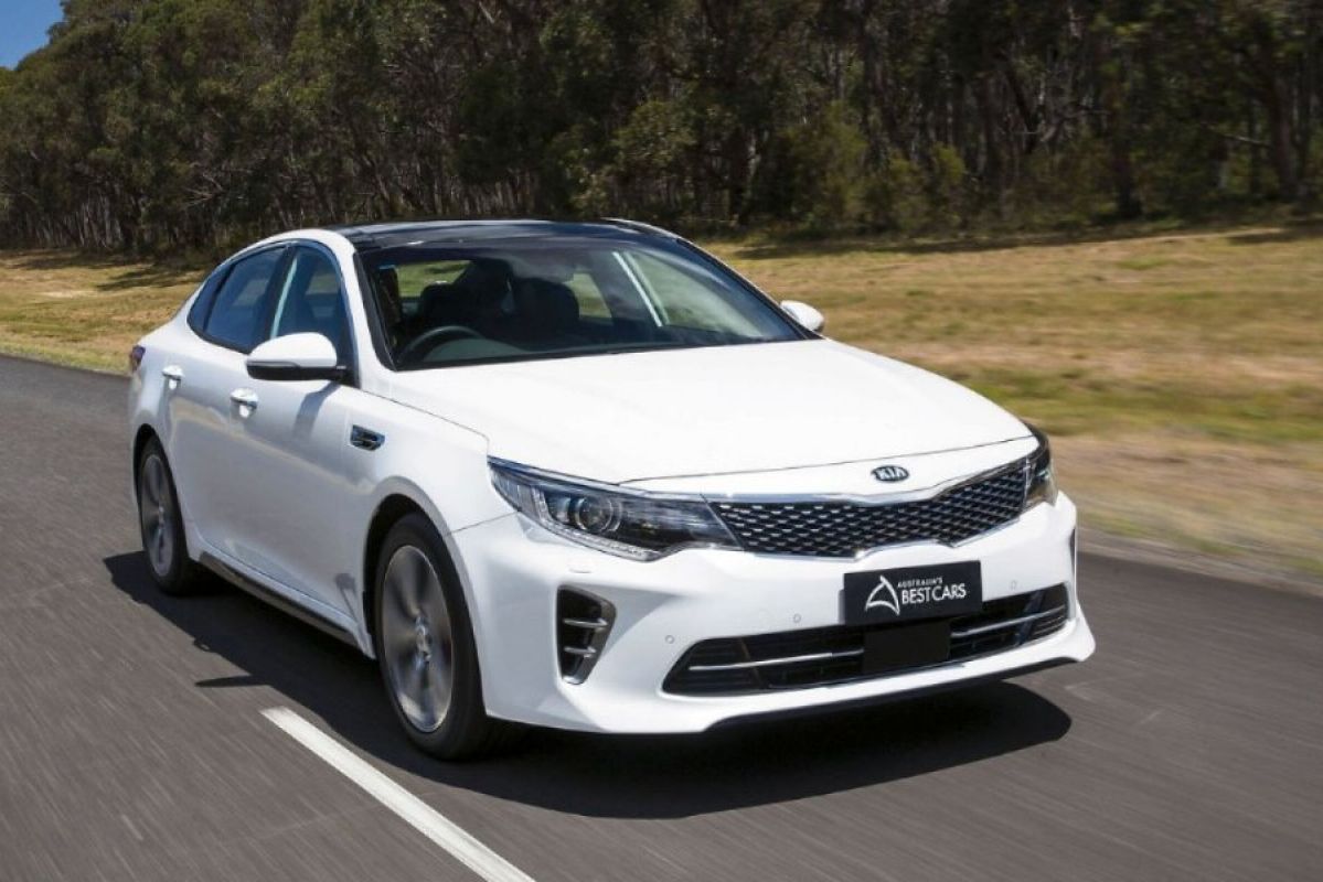 white kia optima gt driving on a road