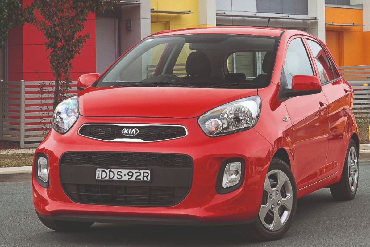 red kia picanto parked outside of house