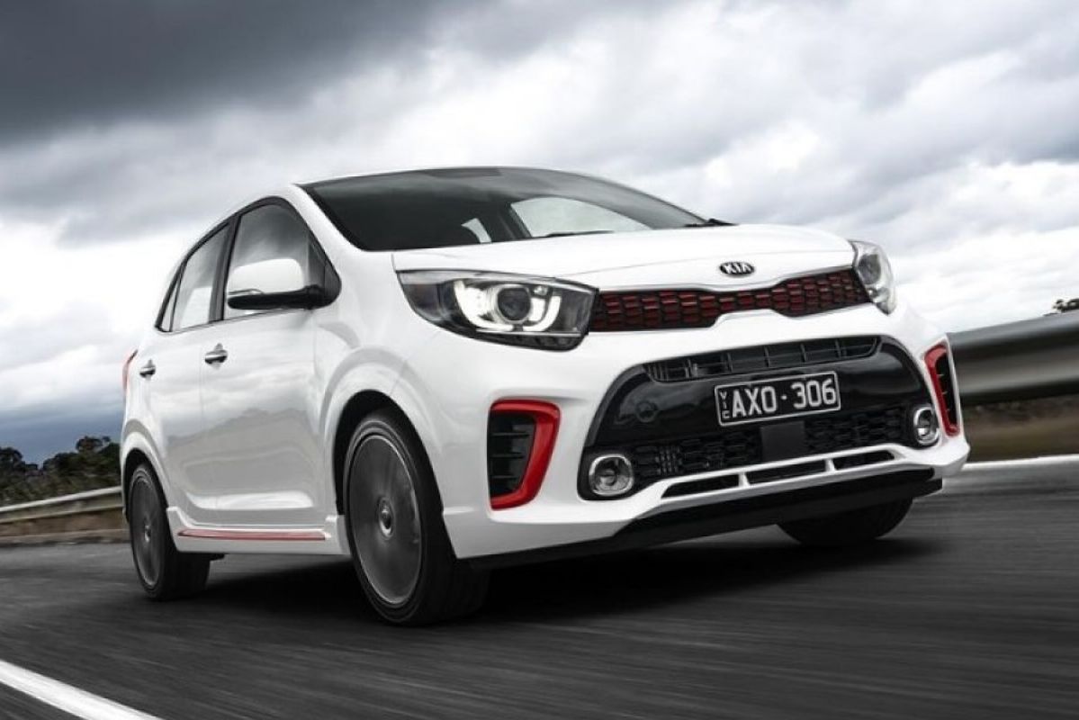 white kia picanto driving on road under cloudy sky