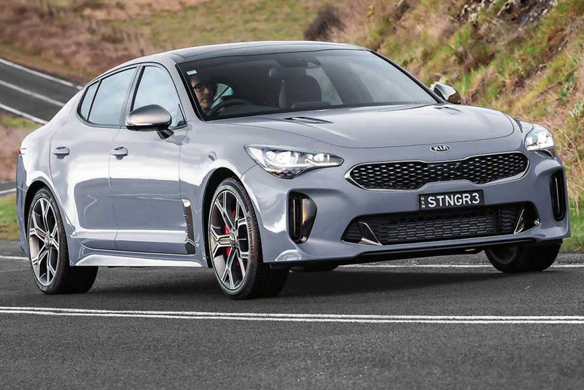 silver kia stinger driving on winding road