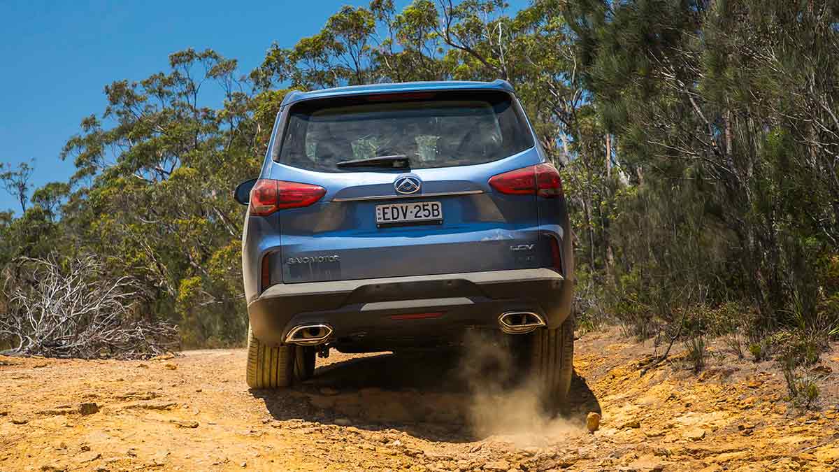 Rear view of a blue LDV D90 driving on a dirt road