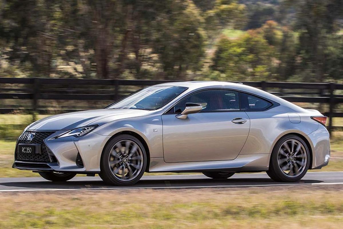 Front side view of a silver Lexus RC350 F Sport Coupe car in motion on a country road