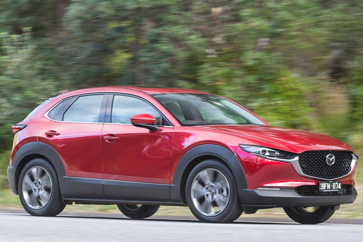 A red Mazda CX-30 small SUV on the road.