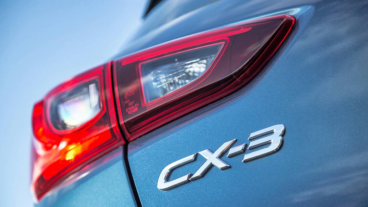 Close up of the CX-3 badge and tail light on a blue Mazda CX-3