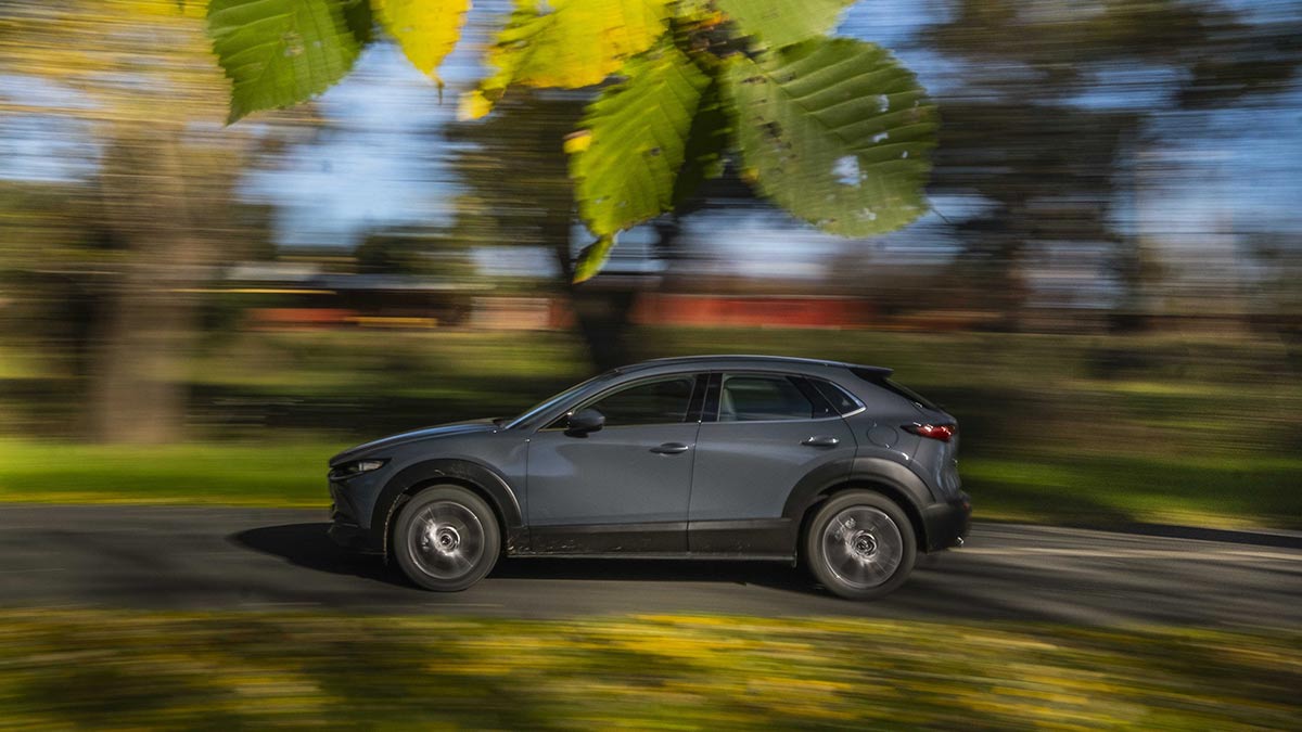 Side view of a grey Mazda CX-30 car in motion