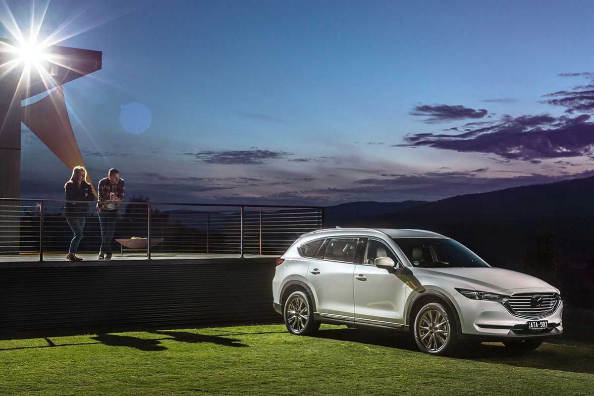 silver mazda cx 8 sport parked on hill next to house at twilight