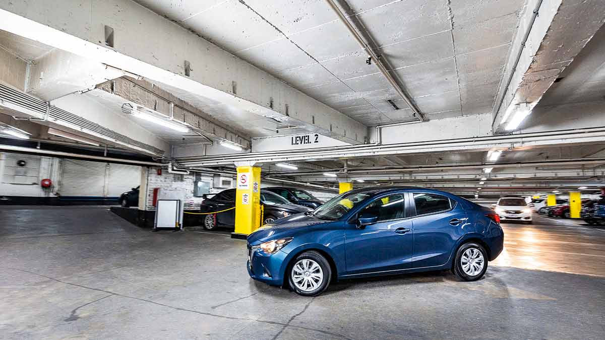 A blue Mazda 2 parked in an undercover car park