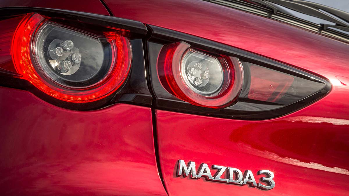 Close up of the tail light and Mazda3 badge on the rear of a red Mazda3 2019 hatch