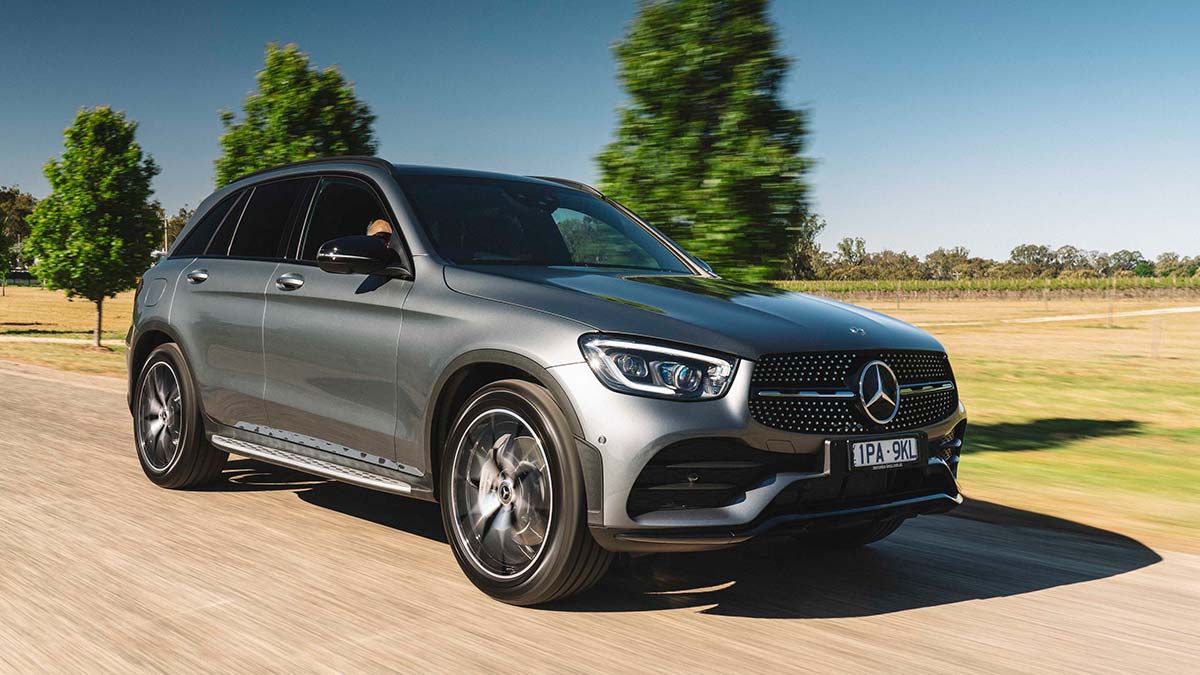 Front side view of a metallic grey Mercedes-Benz C43 4Matic SUV driving on a country road