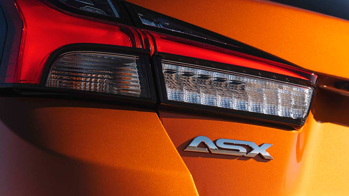 The ASX logo on the rear tail light of an orange Mitsubishi ASX