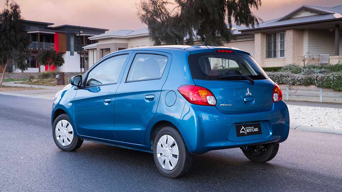 Rear side view of a blue Mitsubishi Mirage parked in a suburban street