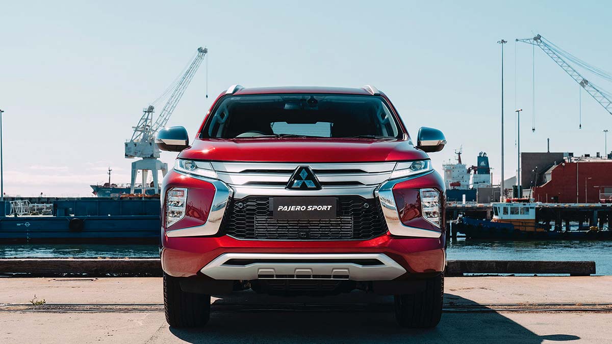 Red Mitsubishi Pajero Sport in front of a port