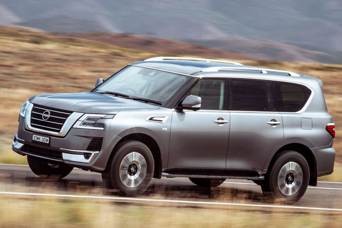 A silver Nissan Patrol drives on the road