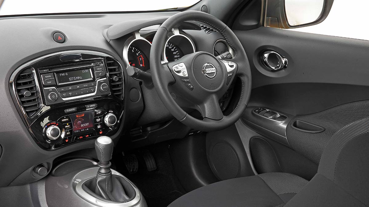 Dark grey interior of the Nissan Juke showing the gear shifter, centre console and steering wheel