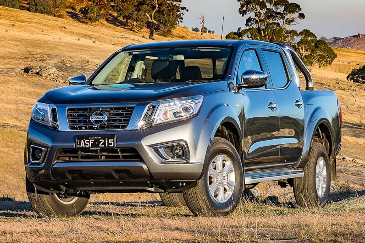 Front side view of a dark grey Nissan Navara 2018 car parked in a field