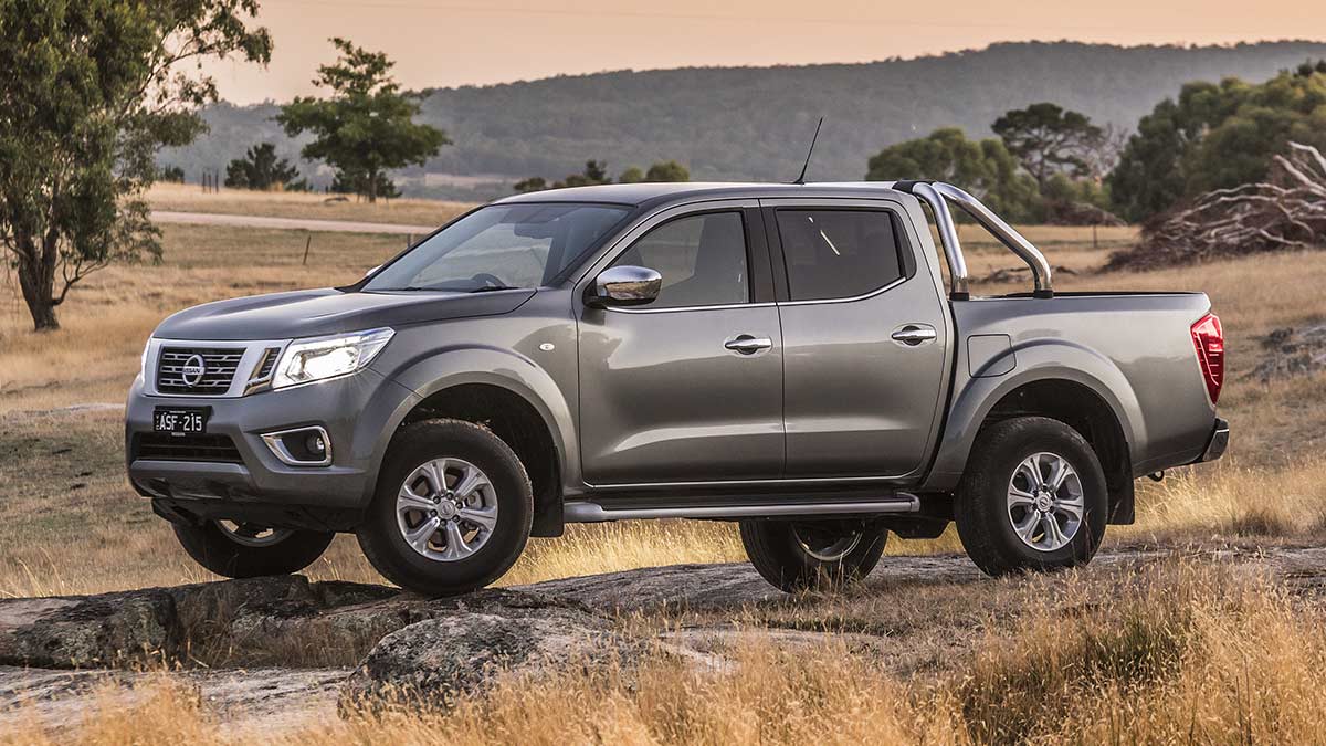 Side view of a dark grey Nissan Navara 2018 car parked in a field