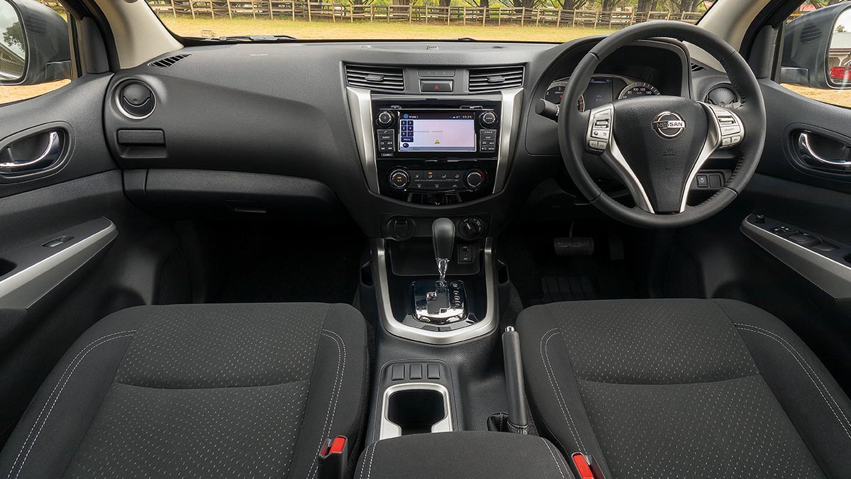 Dark grey interior inside a Nissan Navara 2018 car showing the front seats, dashboard and steering wheel