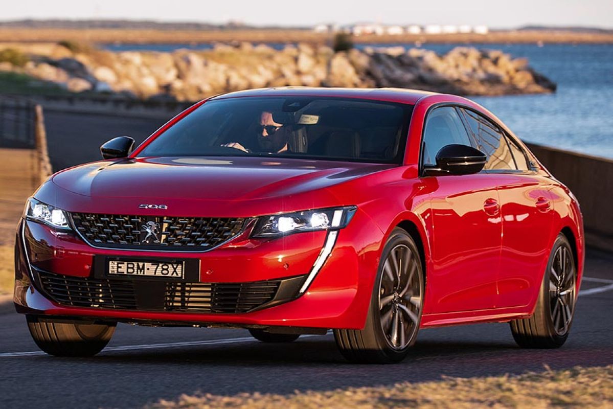 A red Peugeot 508 Fastback on the road.