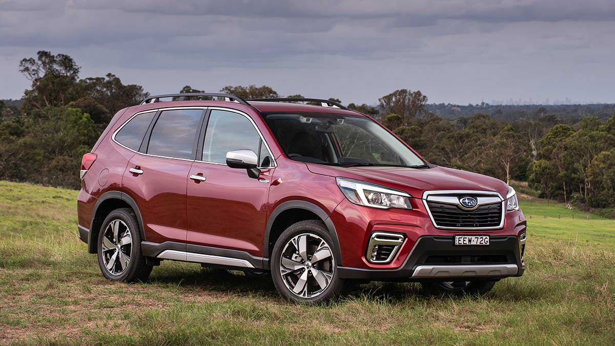 Front side view of a red Subaru Forester Hybrid S 2020 car parked in a country field