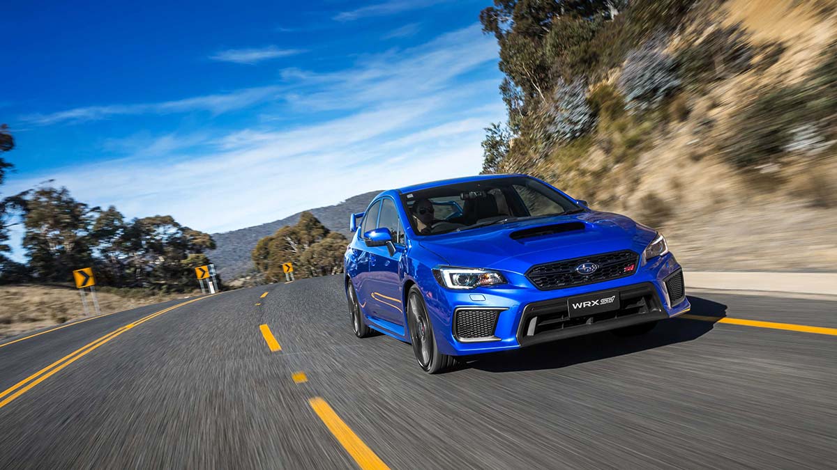 Front side view of a blue Subaru WRX STI spec.R in motion on a road