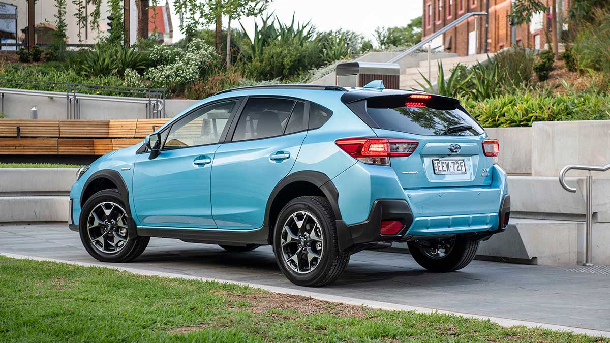 Rear side view of a light blue Subaru XV Hybrid 2020 car parked on concrete