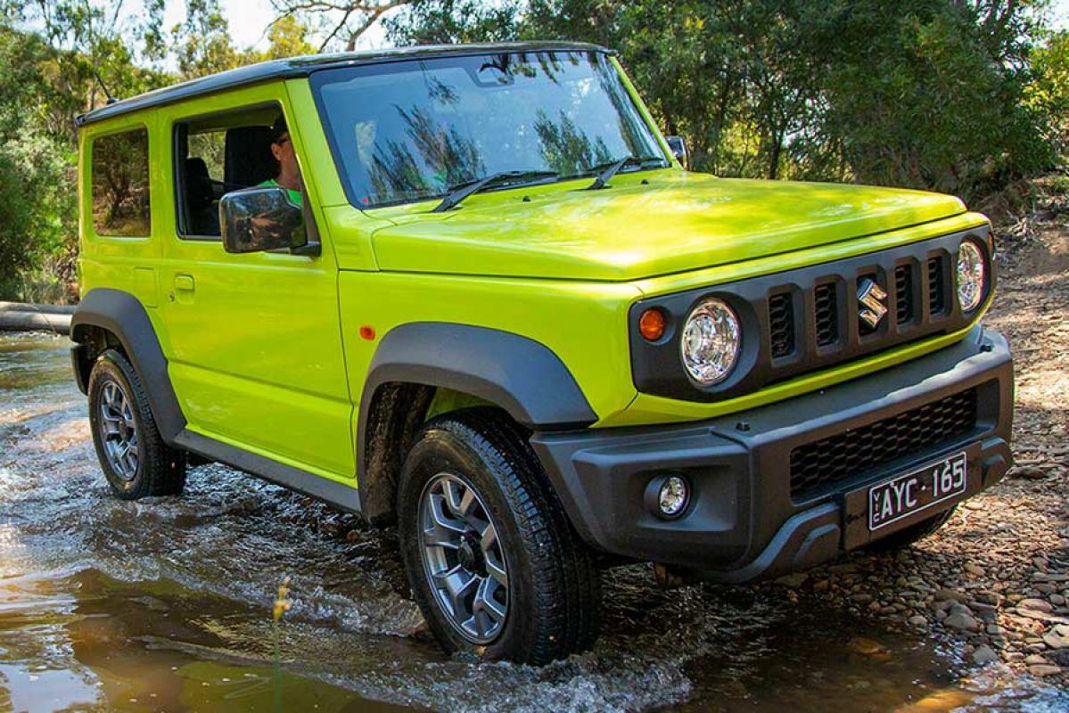 A lime green Suzuki Jimny 2019 car driving through a shallow body of water