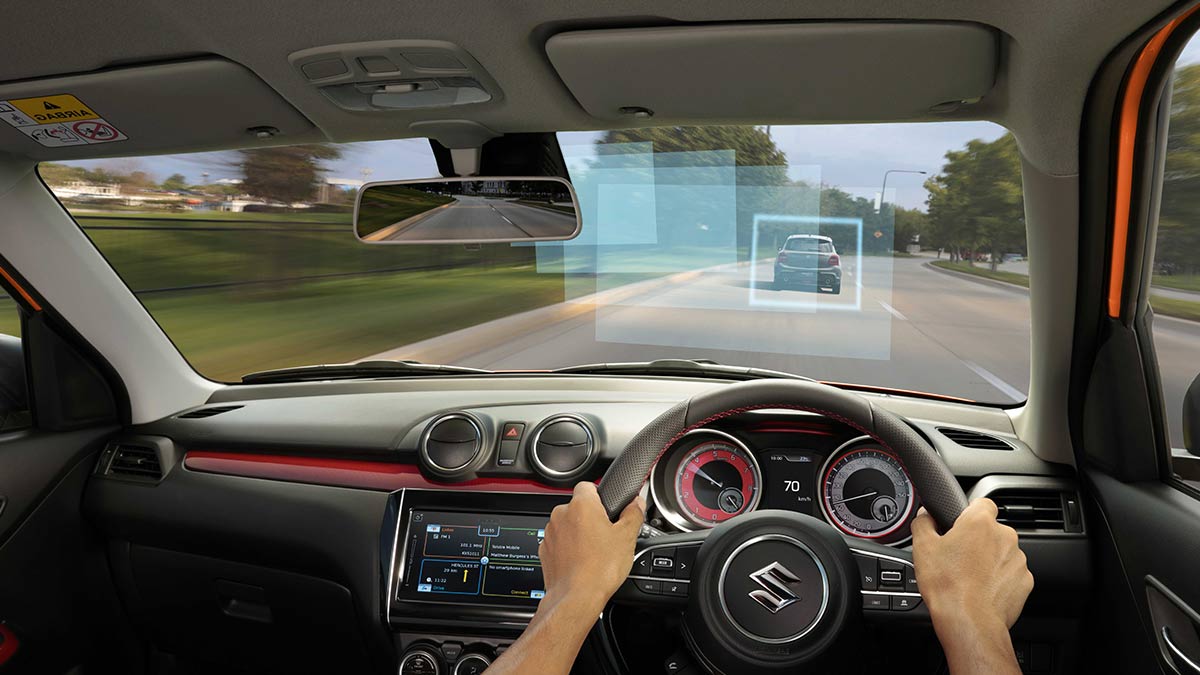 Interior of the Suzuki Swift Sport 2020 showing the windshield and a person's hands on the steering wheel