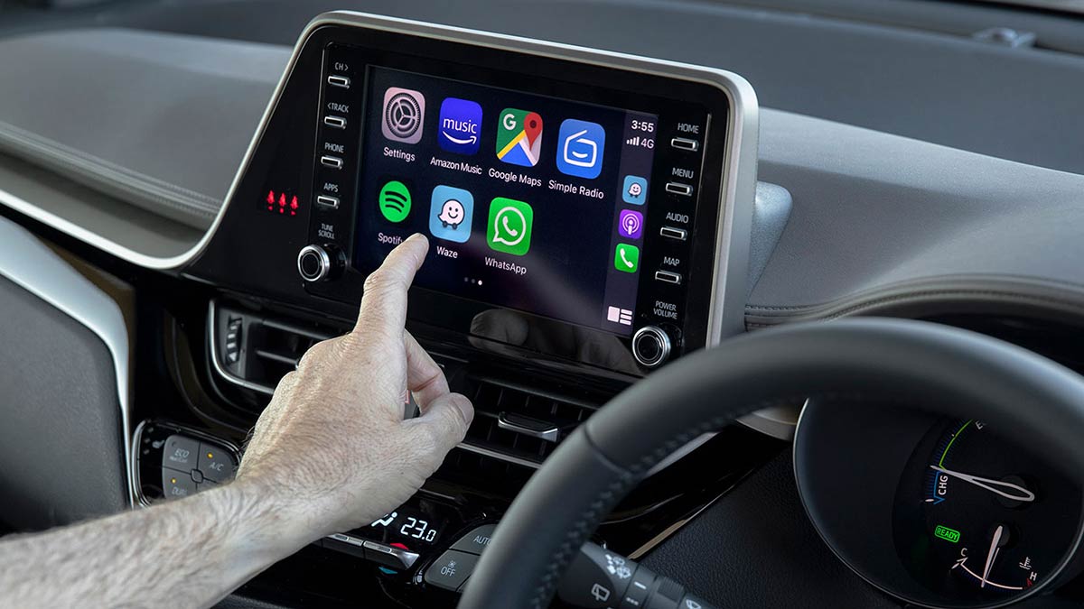 A driver using the Toyota C-HR Hybrid's eight-inch touchscreen