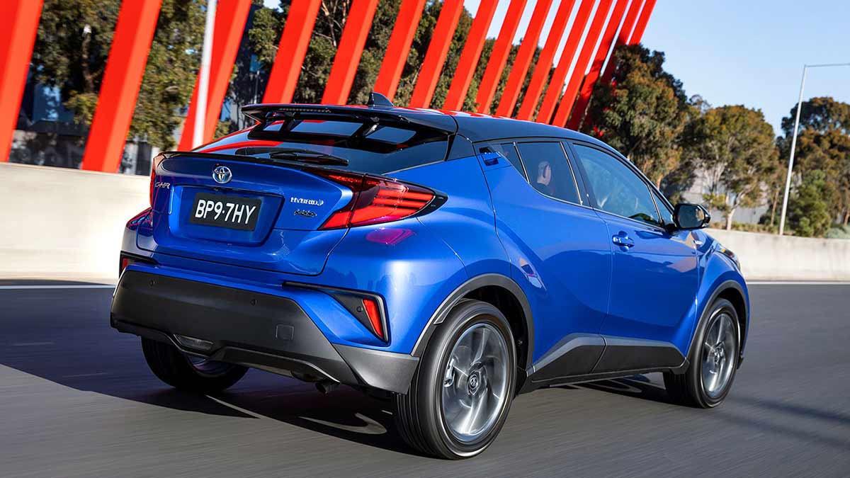 Rear side view of a blue Toyota C-HR Hybrid in motion